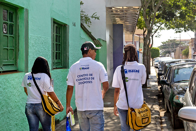 agentes da zoonoses caminhando em uma rua